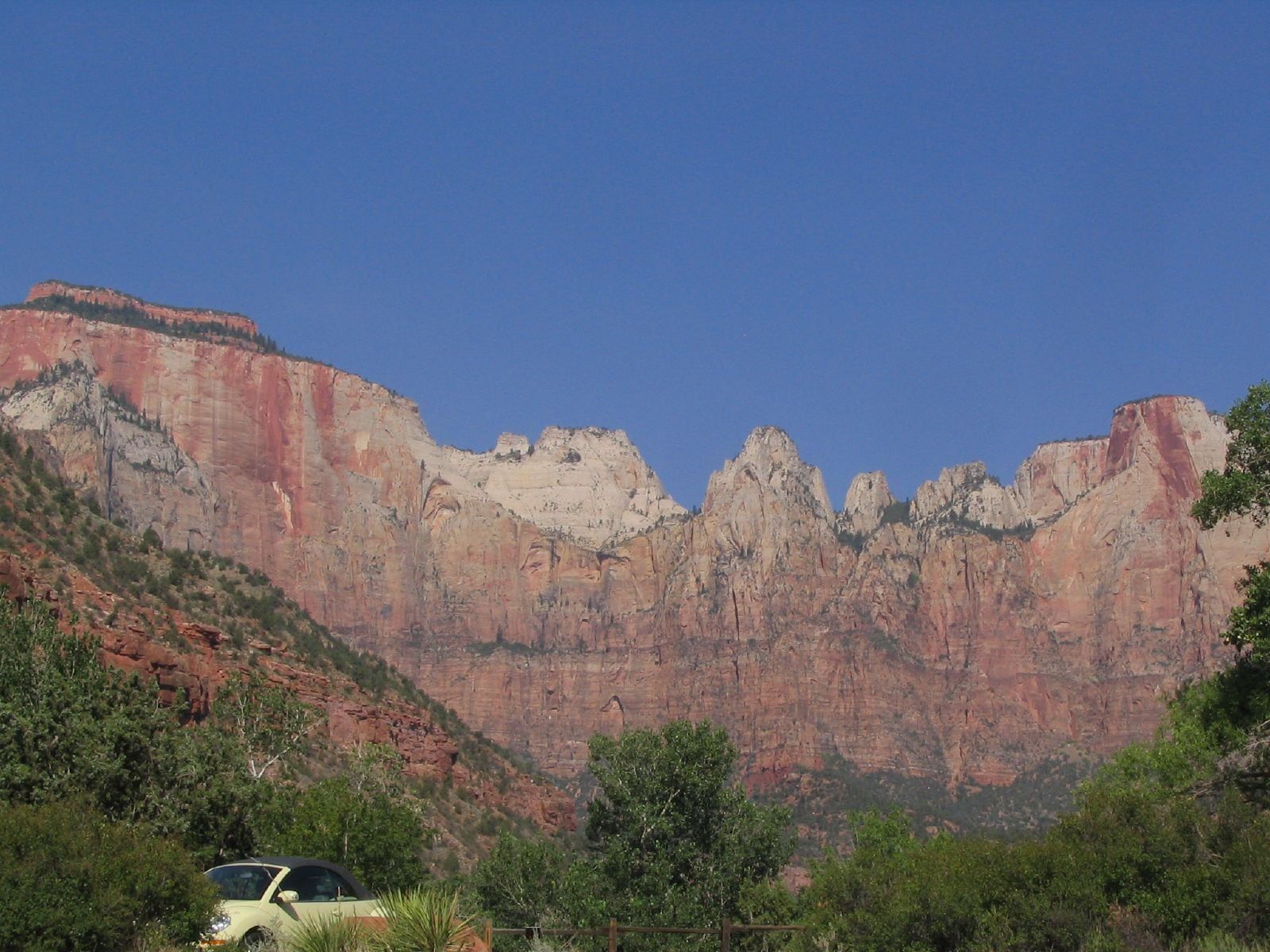 Towers of the Virgin, Zion Canyon Towering red sandstone cliffs of the Towers of the Virgin rise above Zion Canyon under a clear blue sky.