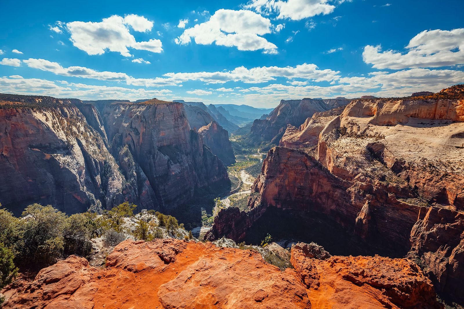 Spectacular panoramic view from Observation Point trail overlooking Zion Canyon's towering red rock cliffs and winding valley below