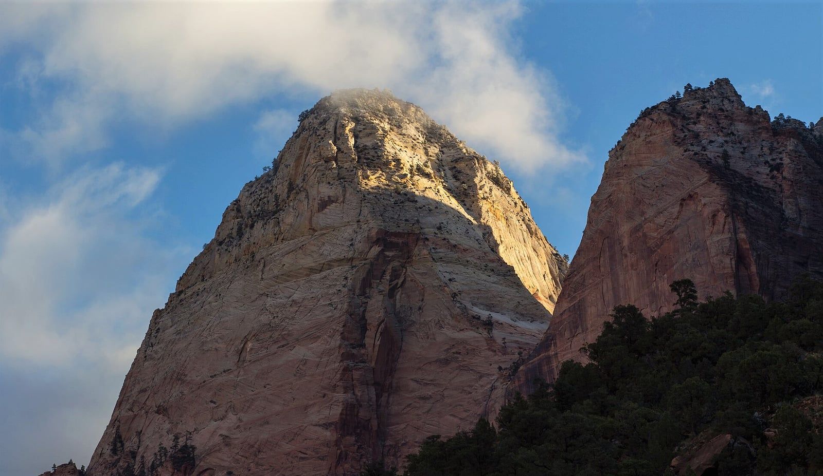 Mountain of the Sun, Zion National Park Sunlit sandstone summit of Mountain of the Sun rising above Zion Canyon with dramatic clouds in southern Utah.