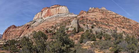 Sweeping panoramic view of East Temple's layered sandstone cliffs along the Canyon Overlook Trail in Zion National Park.