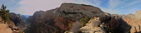 Sweeping panoramic view from Angels Landing showing Zion Canyon, red sandstone cliffs, and the Virgin River below.