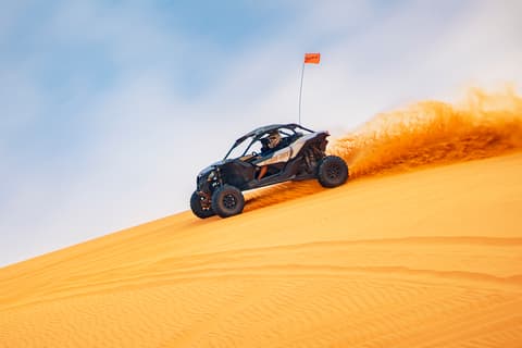 UTV adventure tour kicking up sand on golden dunes for outdoor activities and things to do near Zion National Park