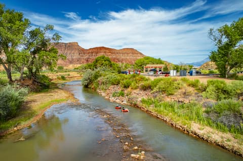 Tubers floating down Virgin River near Zion water rentals outfitter with red rock canyon views and outdoor adventure equipment rental facility