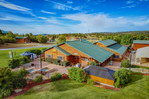 Aerial view of rustic lodge with green metal roof surrounded by cabins and landscaped grounds near Zion National Park