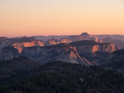A sweeping sunset view from Lava Point in Zion National Park, with pink skies illuminating layered sandstone mesas.