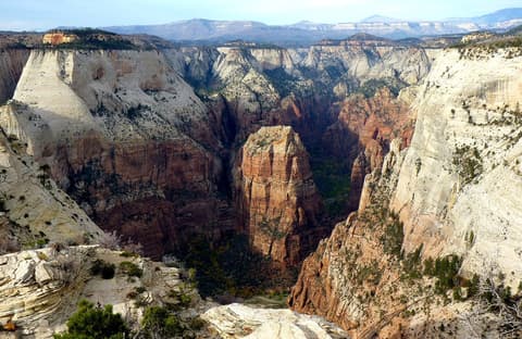 A sweeping aerial view of Angels Landing rising from Zion Canyon, seen from the Observation Point trail in Zion National Park.