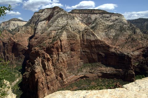 Sweeping view of Zion Canyon's red sandstone cliffs and canyon floor seen from Angels Landing summit.