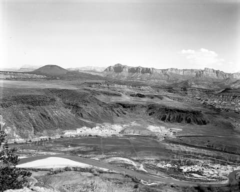 A vintage black and white aerial view of Crater Hill and the Virgin River valley near Grafton, Utah, with Zion's cliffs beyond.
