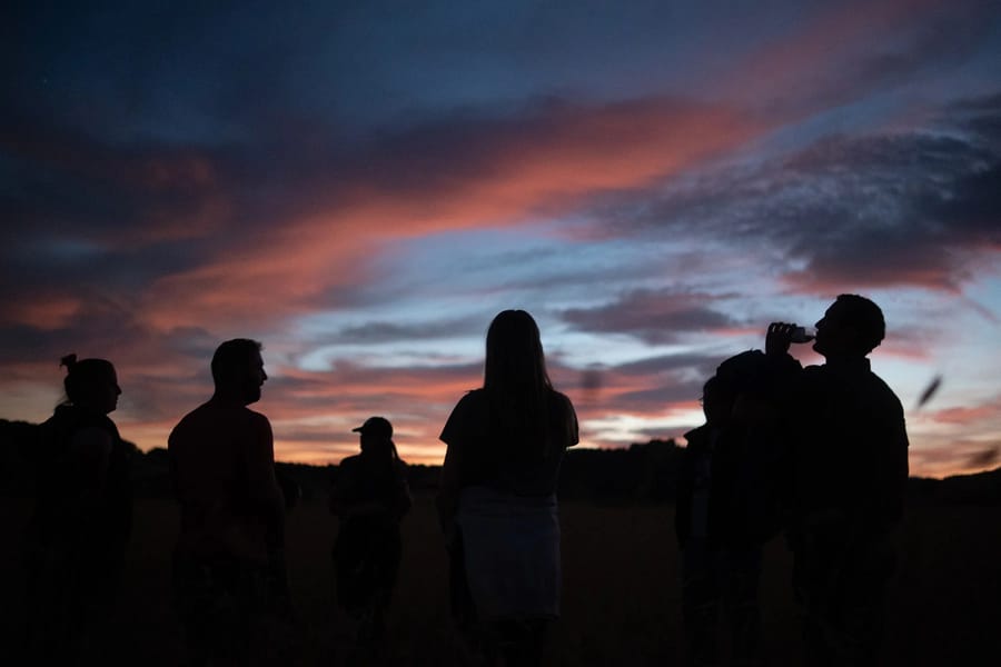 A group of people silhouetted against a vibrant sunset sky in southern Utah near Zion National Park.